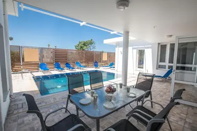 a patio with a table and chairs next to a pool at Napa Nissi House in Ayia Napa