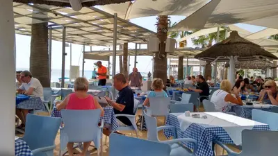 a group of people sitting at tables in a restaurant at Vrissaki Beach Hotel in Protaras