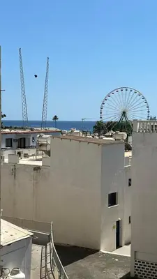 a ferris wheel behind a building with a ferris wheel at Napa Gem in Ayia Napa
