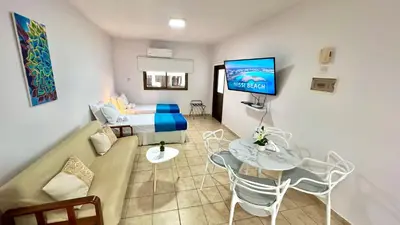 a living room with a couch and a tv on a wall at Napa Gem in Ayia Napa