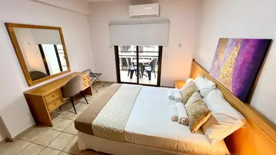 a bedroom with a bed and a desk and a mirror at Napa Gem in Ayia Napa