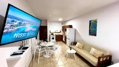 a living room with a couch and a tv on a wall at Napa Gem in Ayia Napa