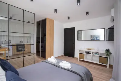 a bedroom with a large bed and a kitchen at STAY Zen Studio in Limassol
