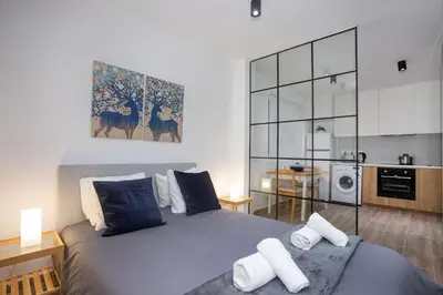 a bedroom with a large bed and a kitchen at STAY Zen Studio in Limassol