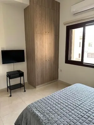 a bedroom with a bed and a wooden cabinet at Chariandry Residence, Limassol City Centre in Limassol