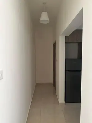 a kitchen with white walls and a black refrigerator at Chariandry Residence, Limassol City Centre in Limassol