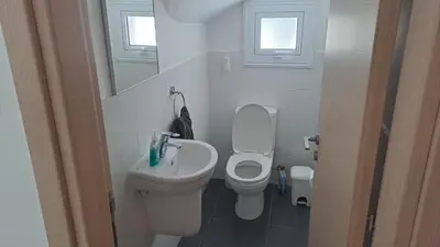 a white bathroom with a toilet and a sink at Relaxing Avra Villa with Private Pool & Garden Near Protaras in Paralimni