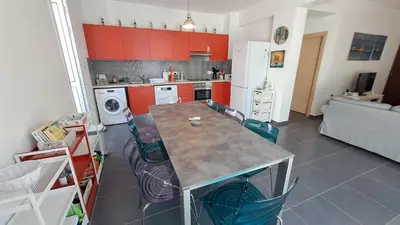 a kitchen with red cabinets and a table and chairs at Relaxing Avra Villa with Private Pool & Garden Near Protaras in Paralimni