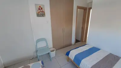 a small bedroom with a bed and a chair at Relaxing Avra Villa with Private Pool & Garden Near Protaras in Paralimni