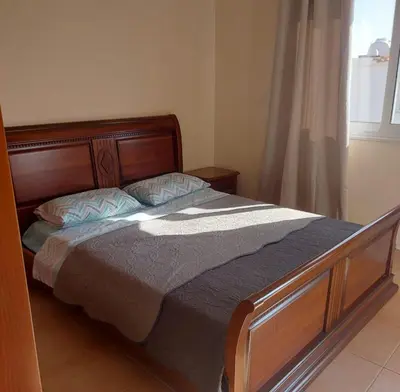 a bedroom with a bed with a wooden frame and a window at The T Villa in Protaras