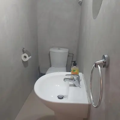 a white bathroom with a toilet and a sink at The T Villa in Protaras