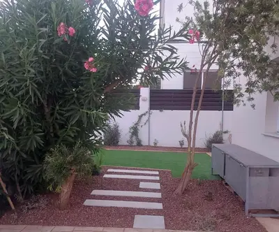 a garden with a bench and some pink flowers at The T Villa in Protaras