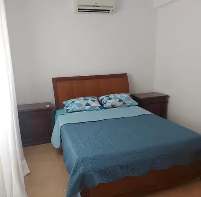a bedroom with a bed with blue sheets and two pillows at The T Villa in Protaras