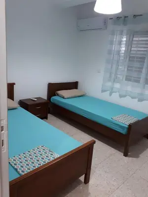 two beds in a room with blue sheets at ALEX FRUIT TREE HOME in Voroklini