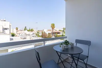 a small table and chairs on a balcony with a view at Hermes 2-Bedroom Apartment in Larnaca in Larnaka