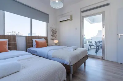 two beds in a room with a balcony at Citrus 3-Bedroom Apartment in Larnaca in Larnaka