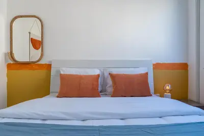 a bedroom with a bed with orange pillows and a mirror at Citrus 3-Bedroom Apartment in Larnaca in Larnaka