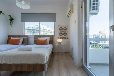 a bedroom with two beds and a large window at Citrus 3-Bedroom Apartment in Larnaca in Larnaka