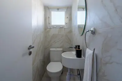 a bathroom with a toilet and a sink and a mirror at Citrus 3-Bedroom Apartment in Larnaca in Larnaka