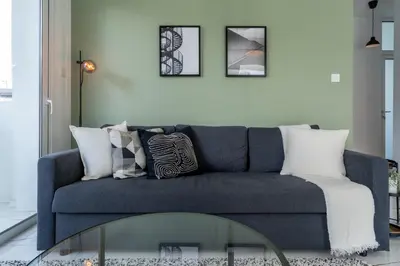 a living room with a blue couch and a glass table at Artemis 1-Bedroom Apartment in Larnaca in Larnaka