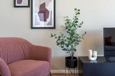 a living room with a chair and a potted plant at Vanilla's Prime 1-Bedroom Apartment in Larnaca in Larnaka