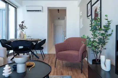a living room with a red chair and a table at Vanilla's Prime 1-Bedroom Apartment in Larnaca in Larnaka