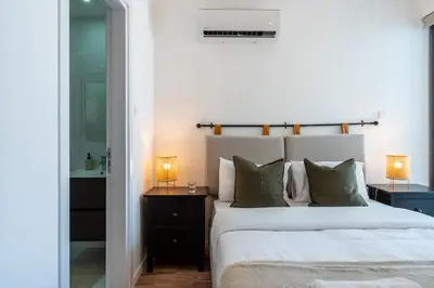 a bedroom with a large white bed with two lamps at Latte's Prime 1-Bedroom Apartment in Larnaca in Larnaka