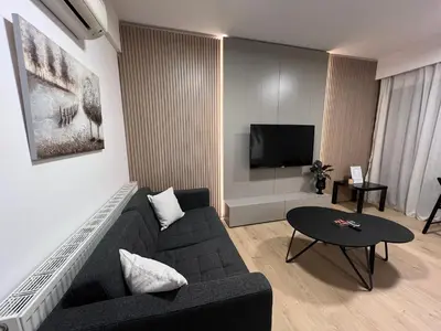 a living room with a couch and a tv at Daniela's modern apartment in Strovolos