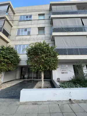 a building with two trees in front of it at Daniela's modern apartment in Strovolos