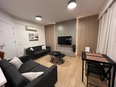 a living room with a couch and a table at Daniela's modern apartment in Strovolos