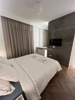 a hotel room with a white bed and a television at Natali's luxury apartment in Strovolos