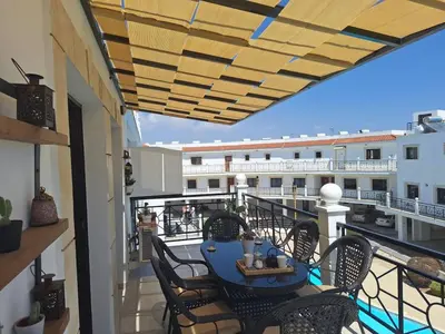 a patio with a table and chairs on a balcony at Paramount Gardens Resorts D204 in Tersephanou
