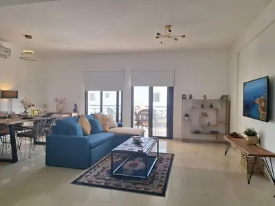 a living room with a blue couch and a table at Paramount Gardens Resorts D204 in Tersephanou