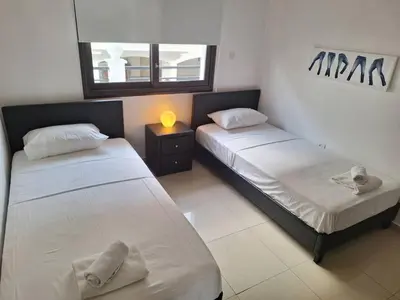 a bedroom with two beds and a mirror and a lamp at Paramount Gardens Resorts D204 in Tersephanou