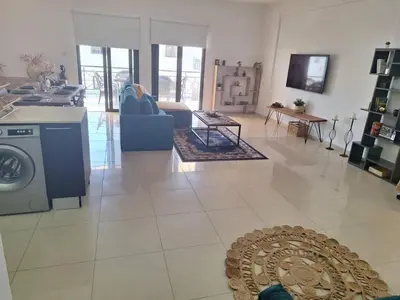 a living room with a kitchen and a living room with a washing machine at Paramount Gardens Resorts D204 in Tersephanou