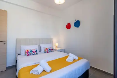 a bedroom with a white bed with towels on it at Diamond’s 2-Bedroom Apartment in Larnaca in Larnaka