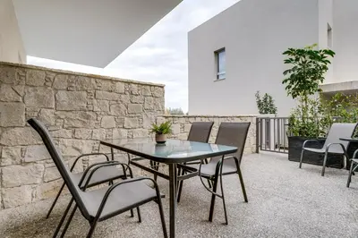 a patio with a table and chairs and a wall at Anchora in Paralimni