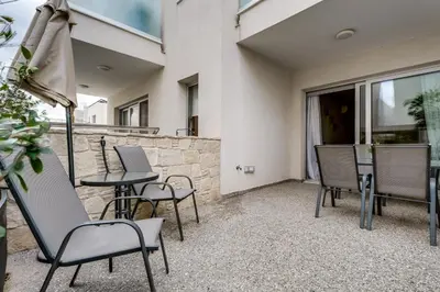 a patio with chairs and a table and an umbrella at Anchora in Paralimni