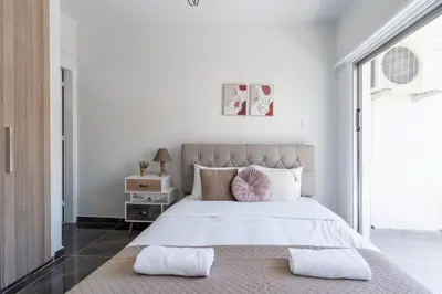 a white bedroom with a large bed with two pillows at Powder’s 1-Bedroom Retreat in Mackenzy, Larnaca in Larnaka