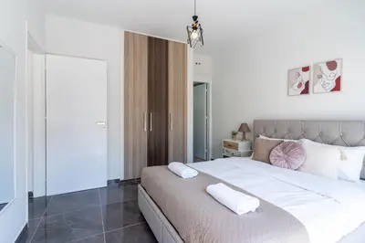 a bedroom with a large bed with two pillows on it at Powder’s 1-Bedroom Retreat in Mackenzy, Larnaca in Larnaka