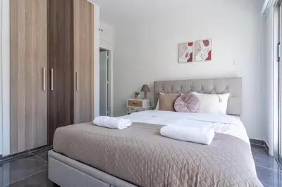 a bedroom with a large bed with two towels on it at Powder’s 1-Bedroom Retreat in Mackenzy, Larnaca in Larnaka