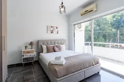 a bedroom with a bed and a large window at Powder’s 1-Bedroom Retreat in Mackenzy, Larnaca in Larnaka