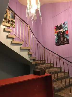 a staircase in a room with a purple wall at Past or Tail hostel in Larnaka