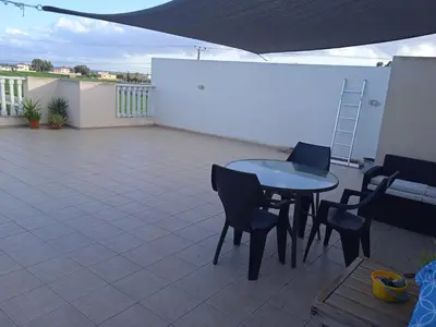 a patio with a table and chairs on a roof at Xylophagou Rest and Relax 3 Ayia Napa Larnaca 1 bedroom apartment in Xylophaghou