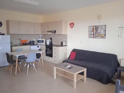 a living room with a couch and a table and a kitchen at Xylophagou Rest and Relax 3 Ayia Napa Larnaca 1 bedroom apartment in Xylophaghou