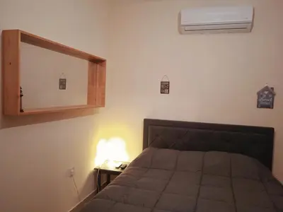 a bedroom with a bed and a mirror on the wall at Xylophagou Rest and Relax 3 Ayia Napa Larnaca 1 bedroom apartment in Xylophaghou