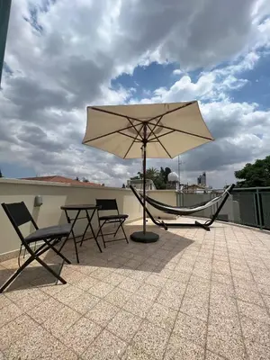 a table and chairs and an umbrella on a roof at Nicosia City Centre Luxury Renovated Apartment in Nicosia