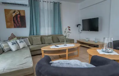 a living room with a couch and a tv at Sun & Sand Private Villa in Protaras