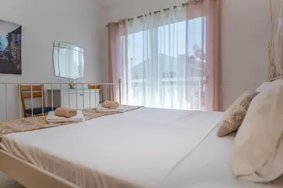 a bedroom with a large white bed with a window at Sun & Sand Private Villa in Protaras