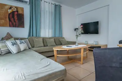 a living room with a couch and a table with a tv at Sun & Sand Private Villa in Protaras